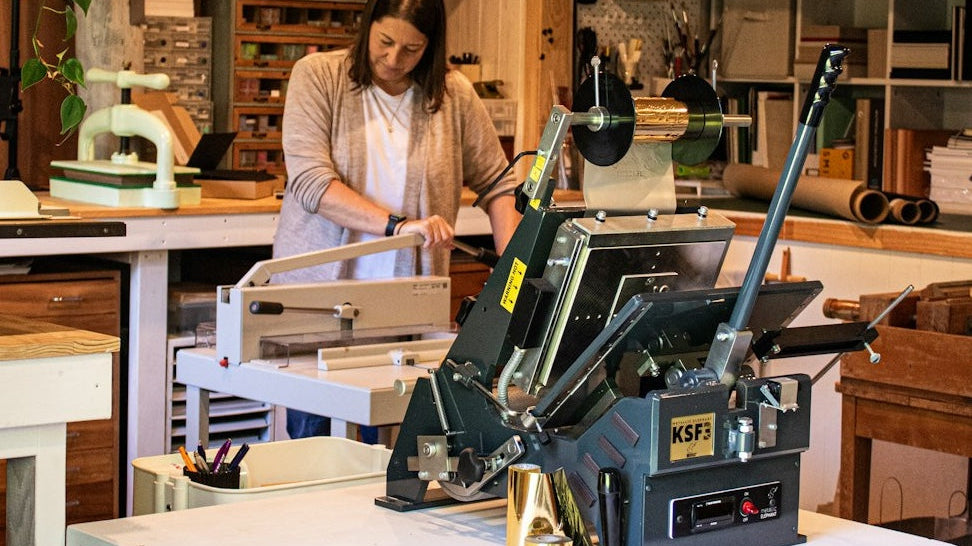 Tracey from My Guestbook making a custom guestbook inside her Auckland studio, surrounded by bookbinding tools.