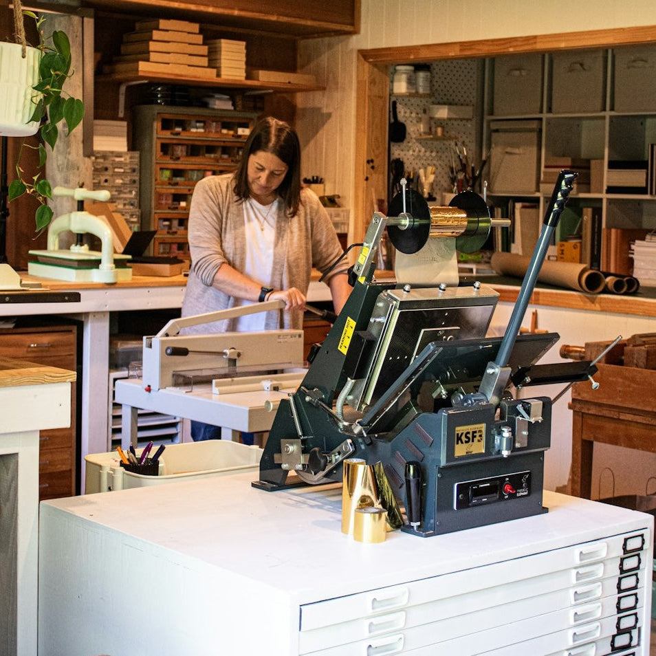 Tracey from My Guestbook making a custom guestbook inside her Auckland studio, surrounded by bookbinding tools.