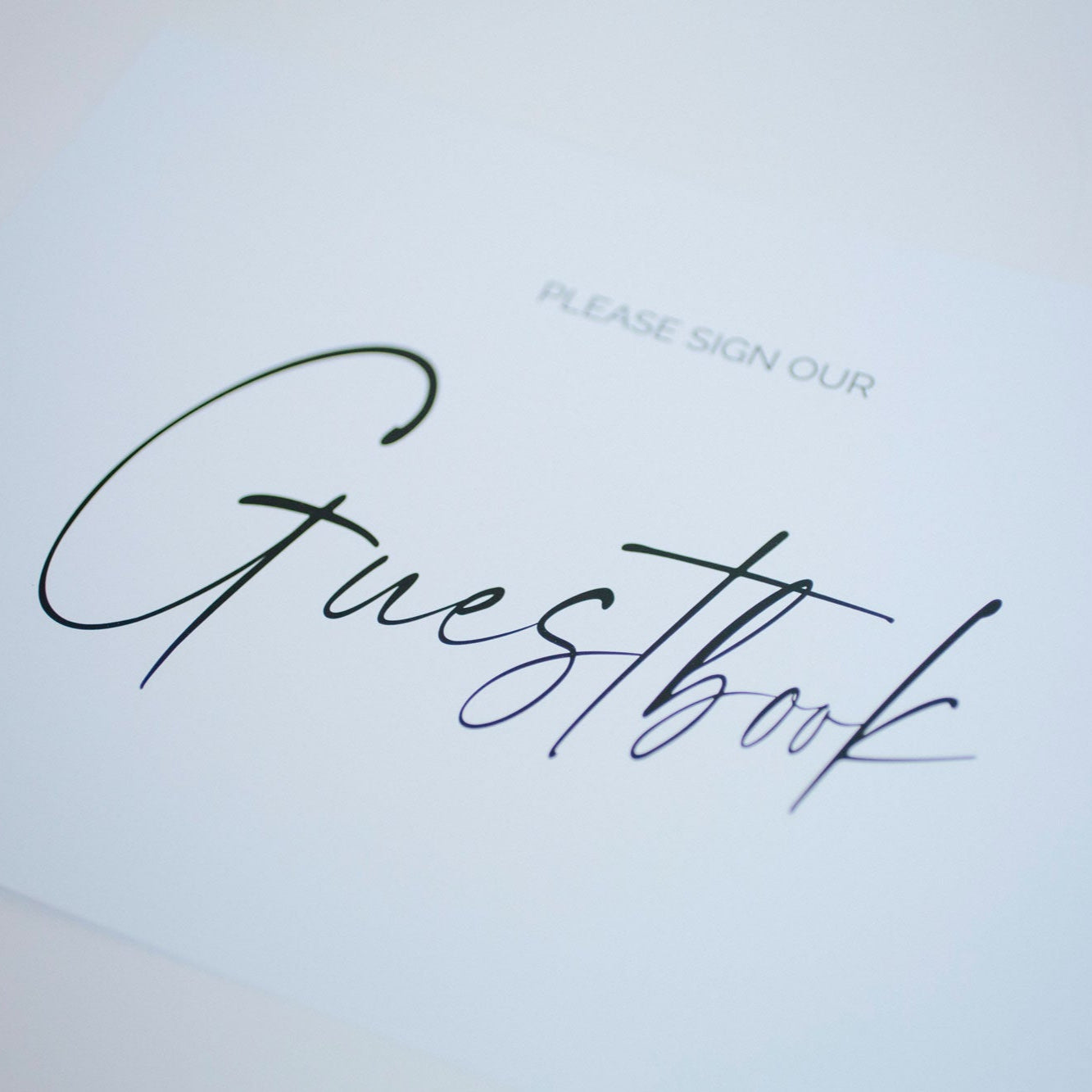 Guestbook cover with 'Please sign our guestbook' text on a light background