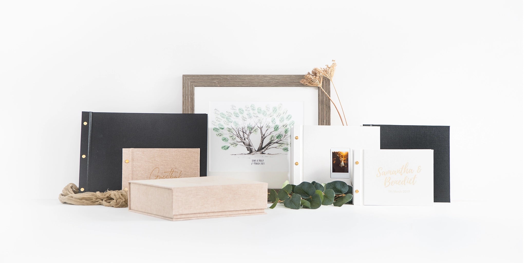 Collection of photo frames and guestbook albums on a white background
