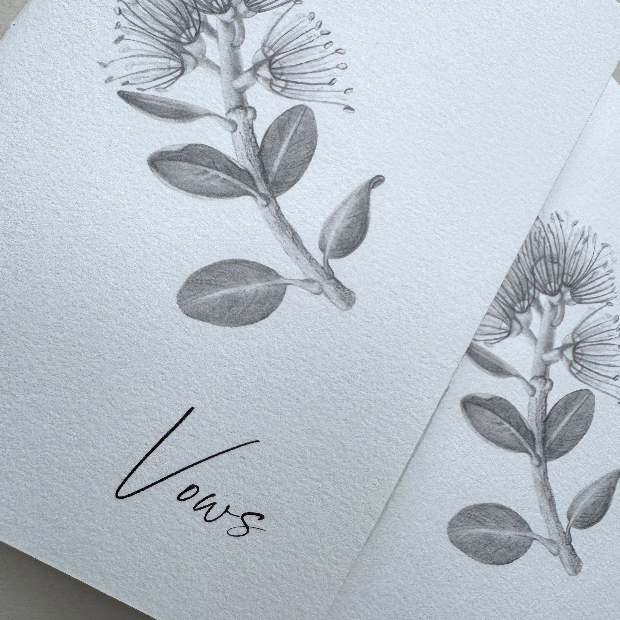 Stationery with floral design and the word 'Vows' on a light background