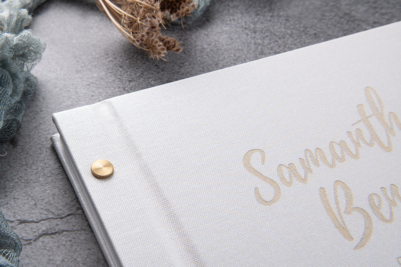 pearl white guestbook with gold writing and binding