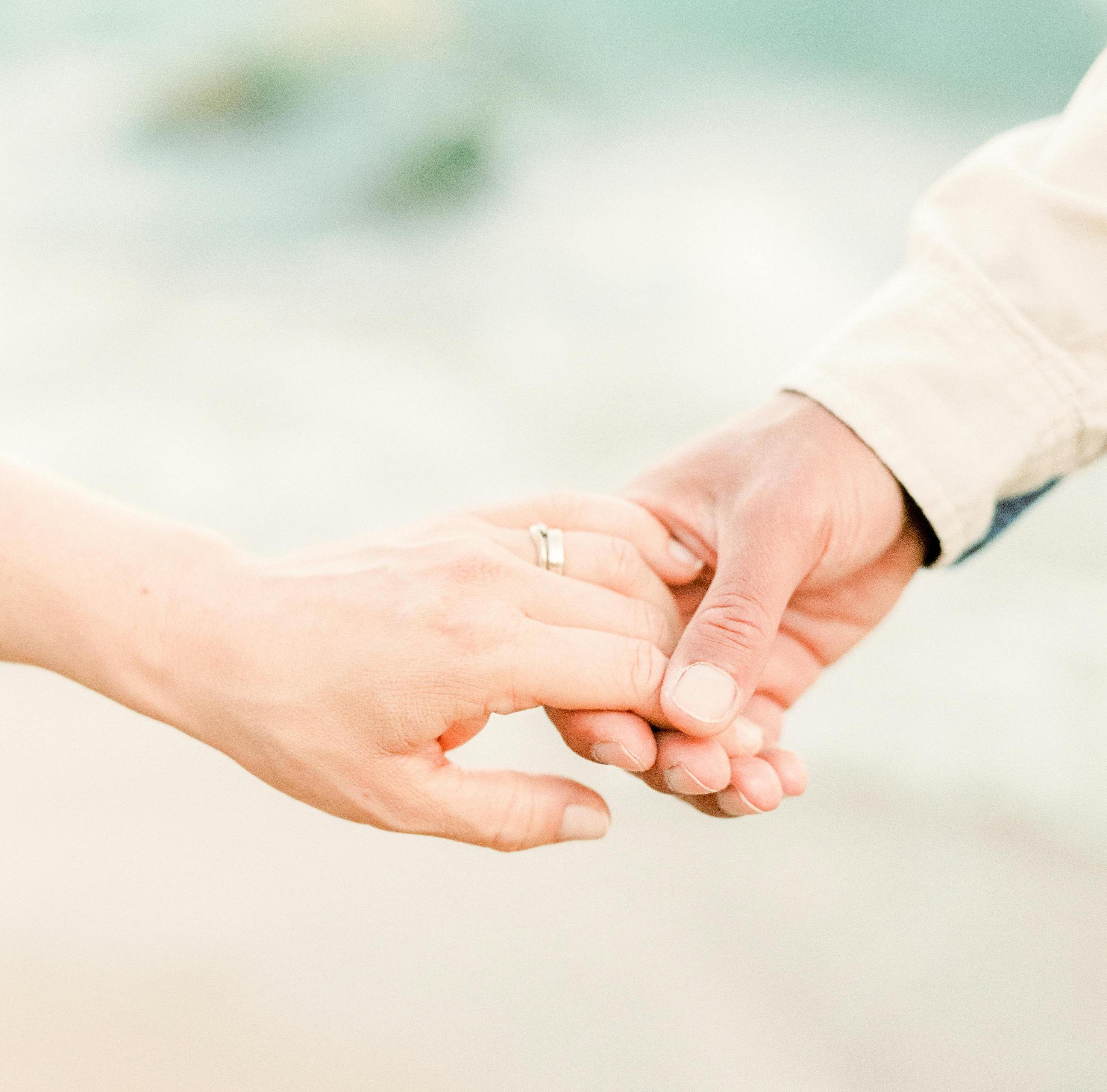 engaged couple holding hands