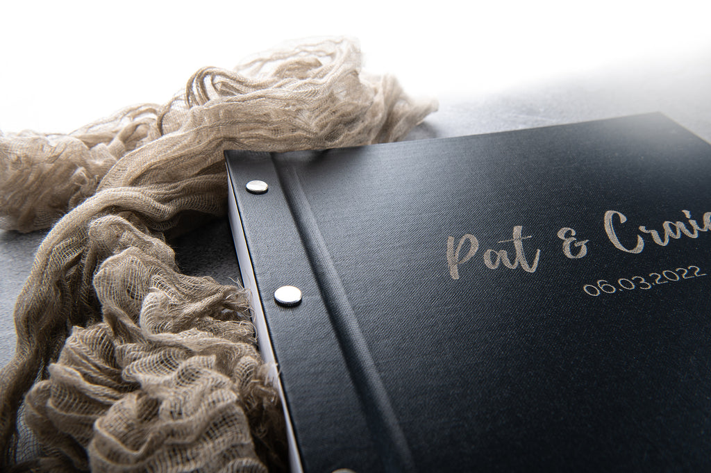 black wedding guestbook with linen fabric in background