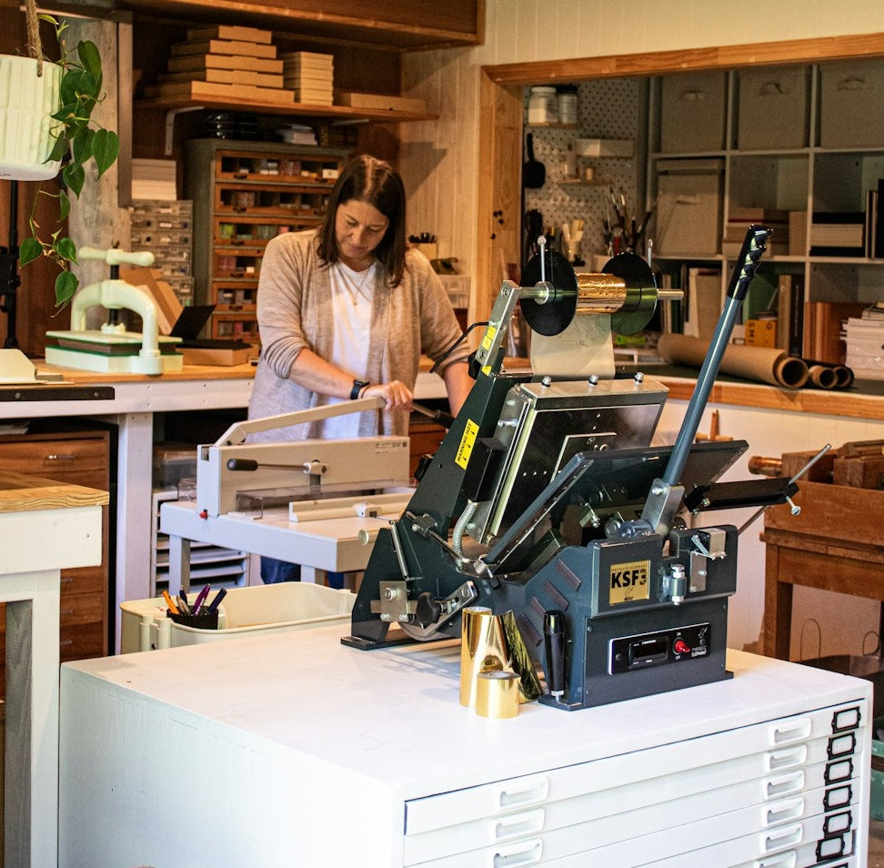 Tracey from My Guestbook making a custom guestbook inside her Auckland studio, surrounded by bookbinding tools.