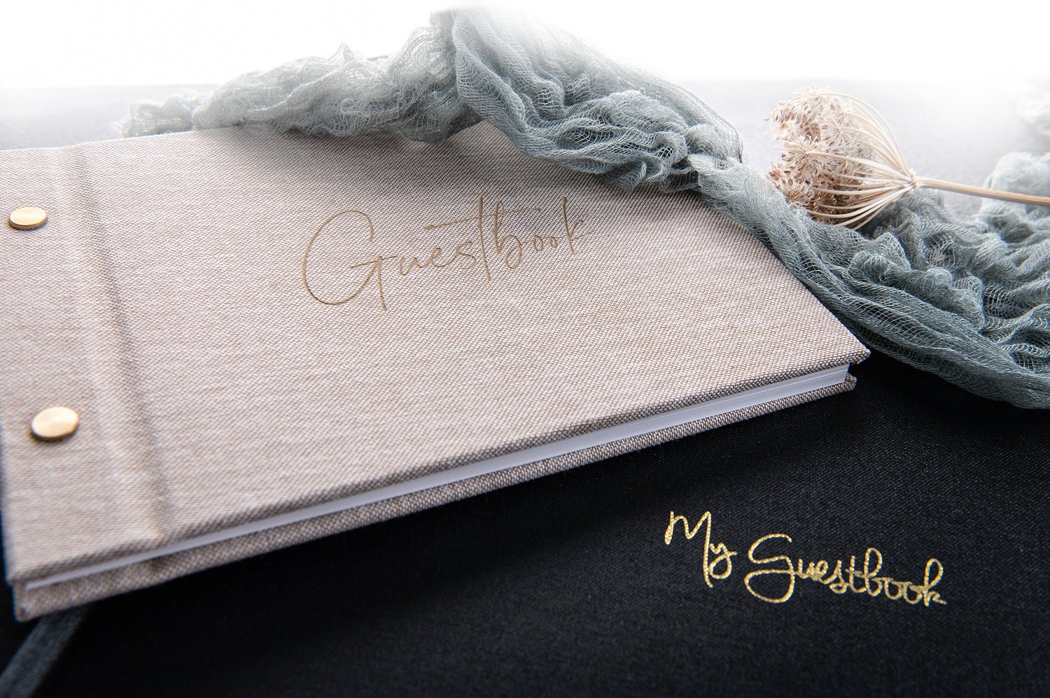 Linen book and black guestbook on a table 