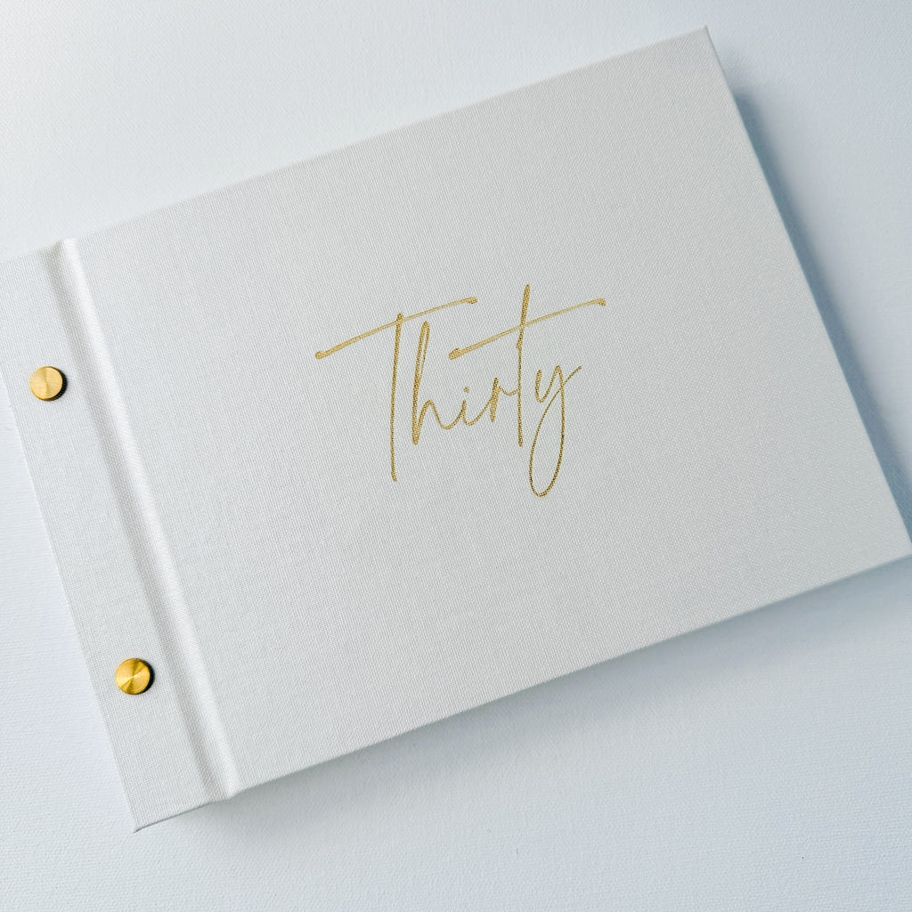 white book with gold writing on cover which says thirty in gold script font