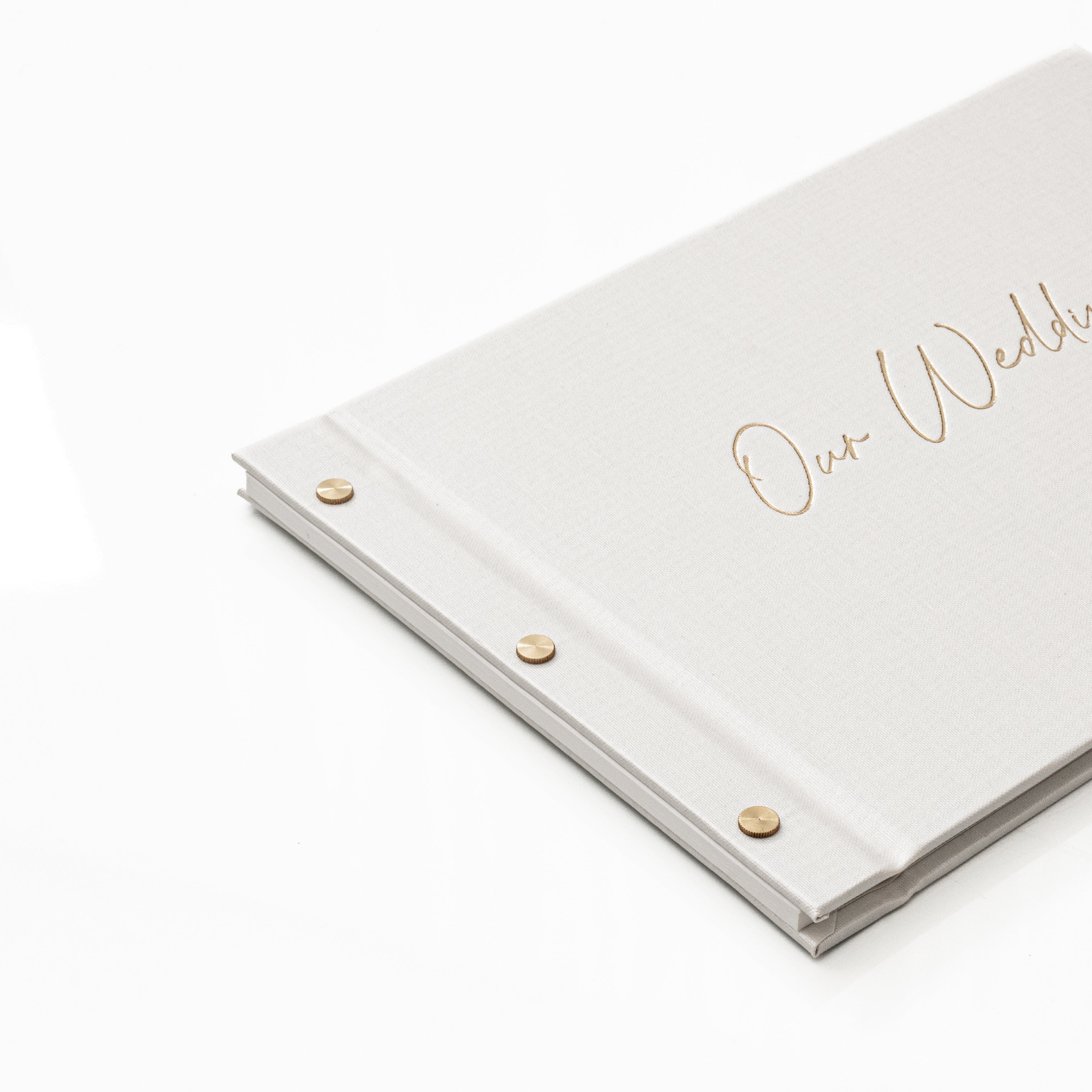 Close-up of gold foil Our Wedding guestbook corner and binding detail