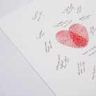 Close-up of a red fingerprint-style heart with guests’ handwritten wedding messages around it