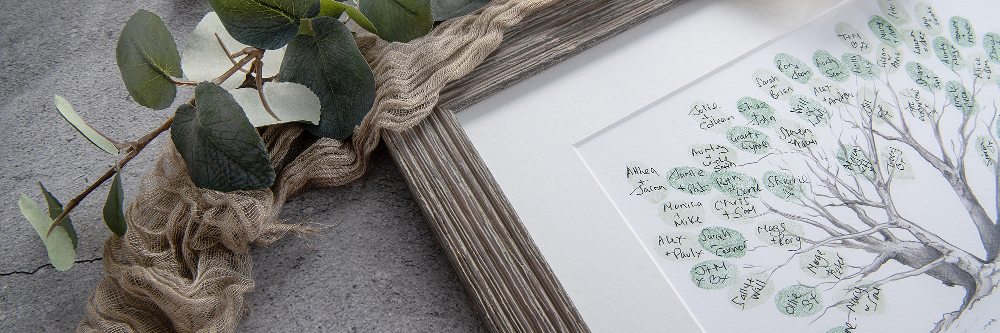 Framed artwork with a fingerprint tree guestbook design on a textured surface