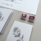 Two ink pads with floral designs on a surface with stationery items.