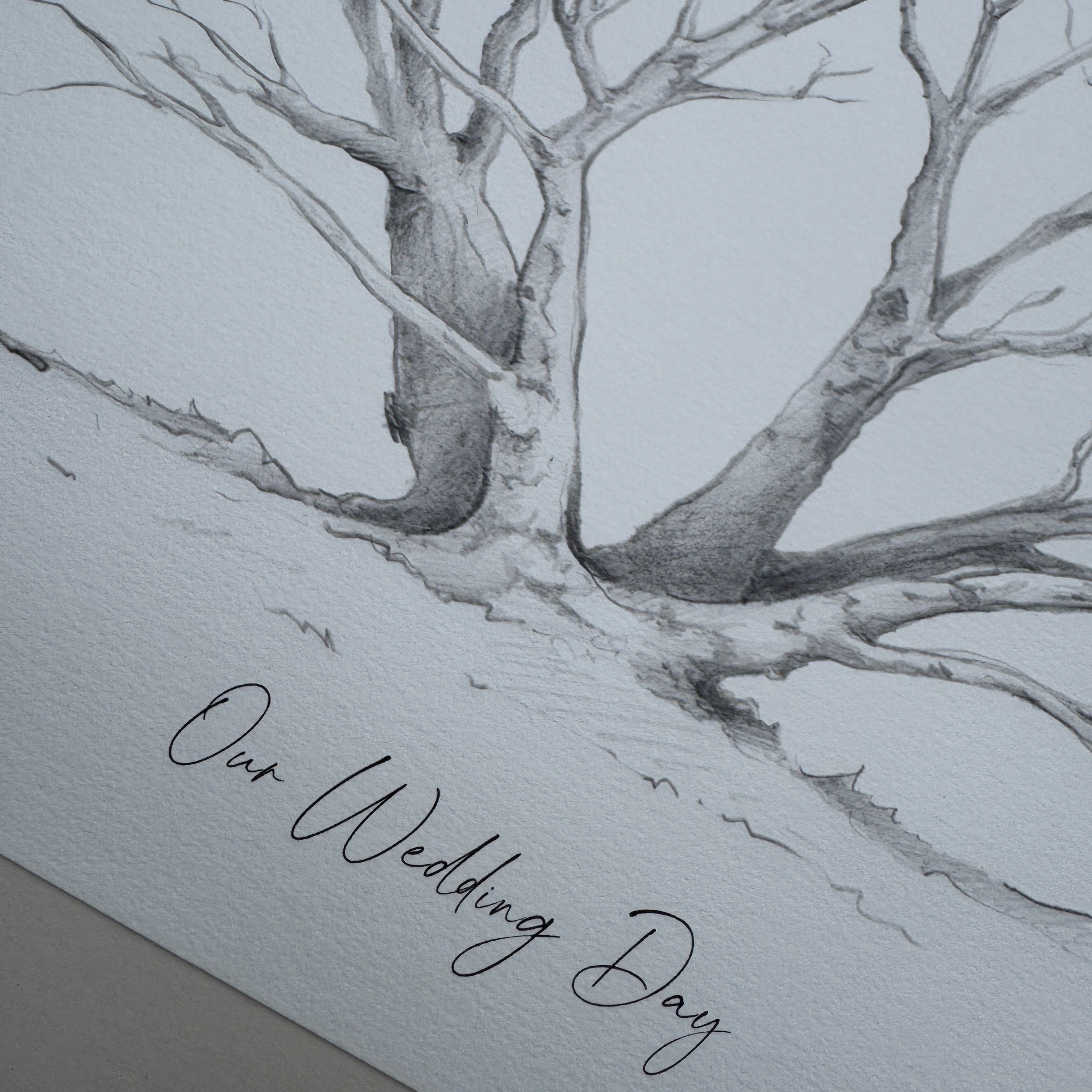 Pencil drawing of a tree with 'Our Wedding Day' text on a textured paper background