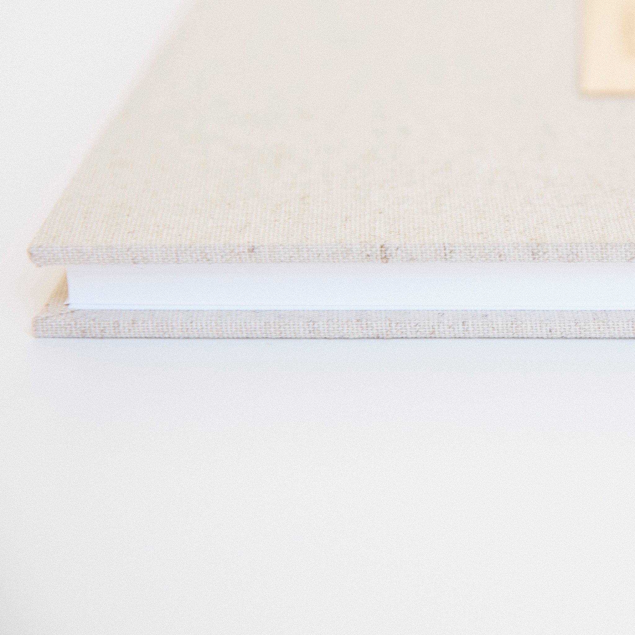 Side view of oatmeal linen guestbook with gold Chicago screw binding