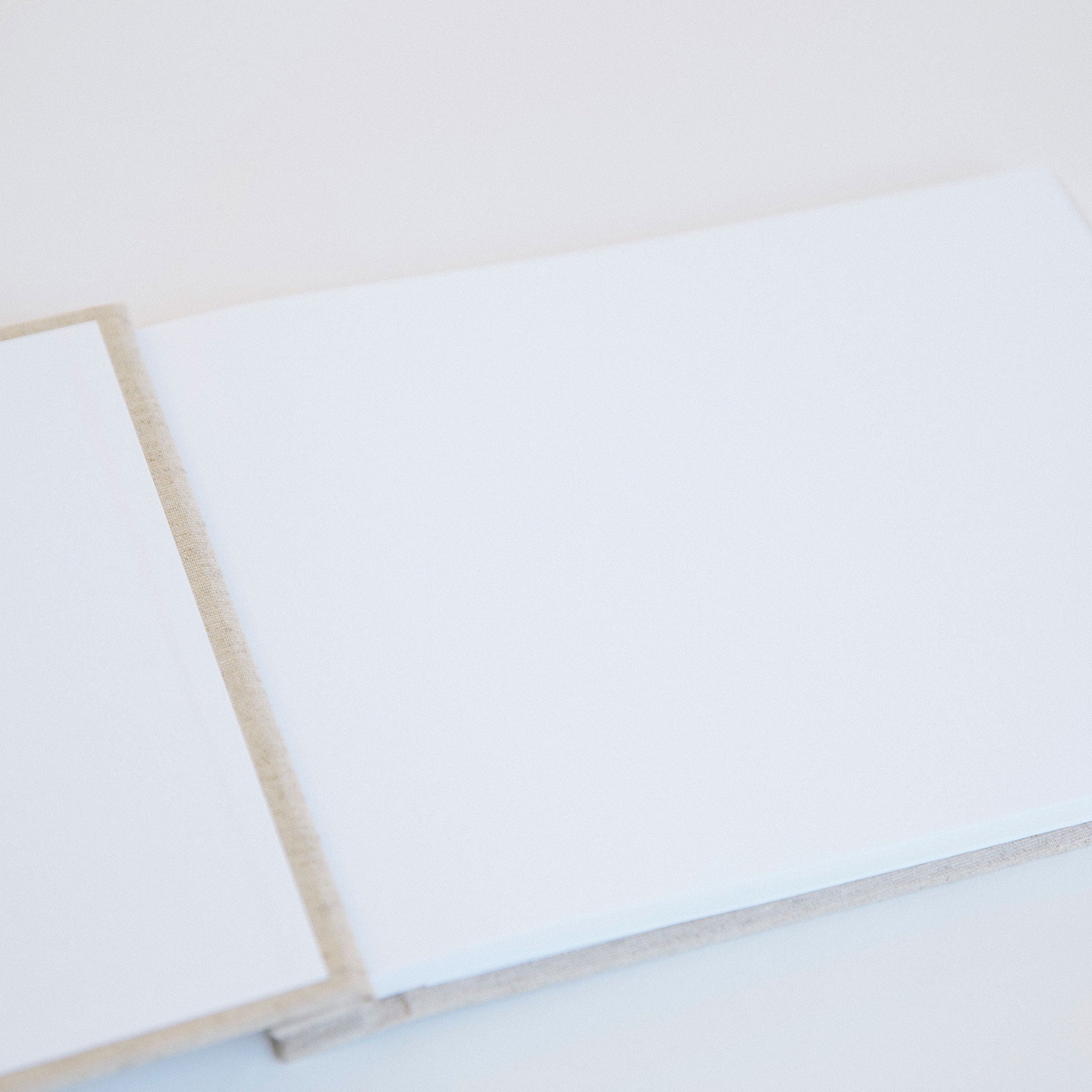 Open A4 guestbook showing Mohawk Superfine pages with gold screw binding